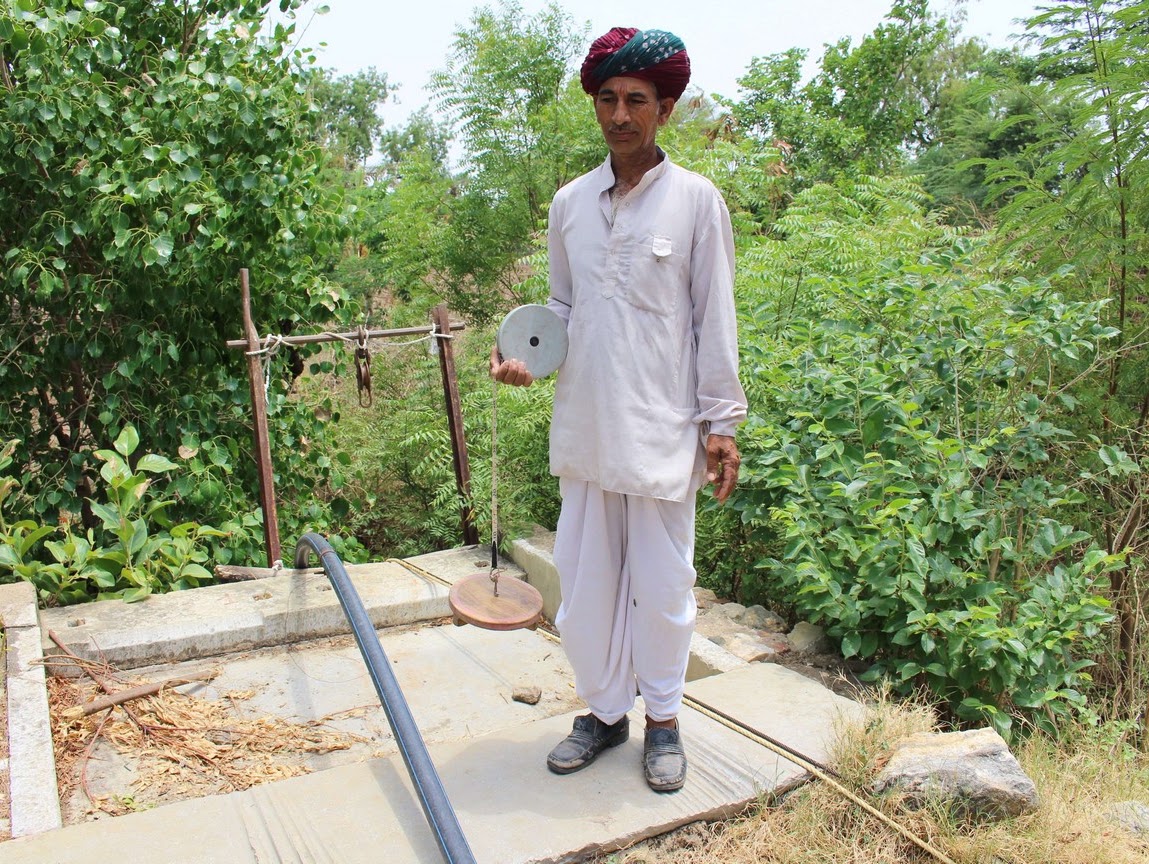 A Bhujal Jaankaar (BJ) (groundwater informed volunteer) taking a measurement beside a village well